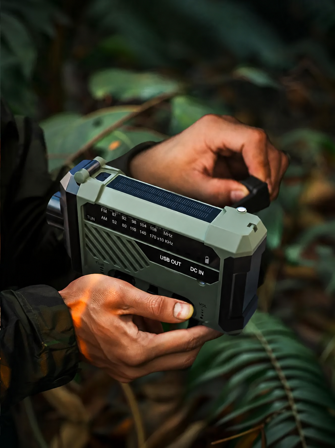 Hand-crank operation with the solar panel visible on top of the radio