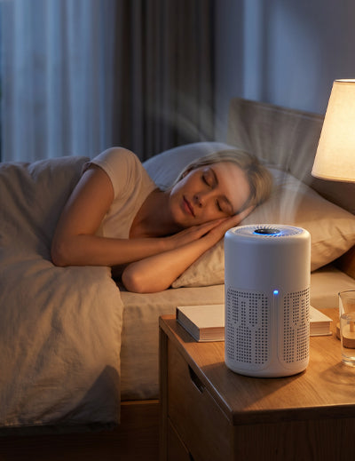 White air purifier placed beside a bed